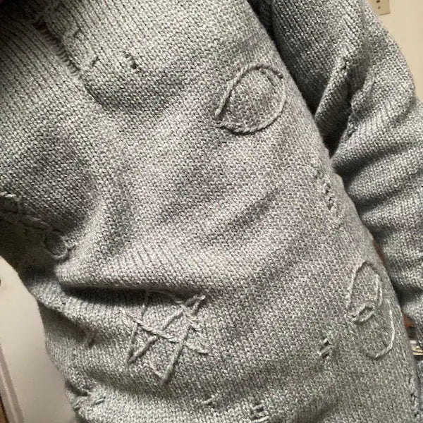 Distressed gray cable knit sweater with embroidered symbols, inspired by the Agatha All Along theme.