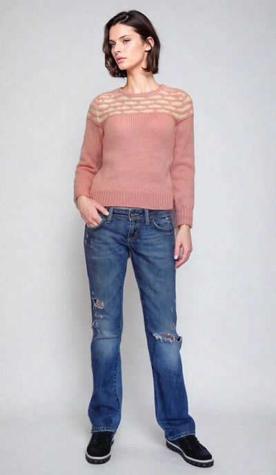 Woman wearing a Honeycomb pink sweater inspired by Promising Young Woman, paired with jeans for a stylish look.