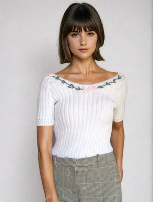 Marilyn Monroe-inspired off-shoulder knit top with floral embroidery in white, featuring short sleeves and ribbed texture.