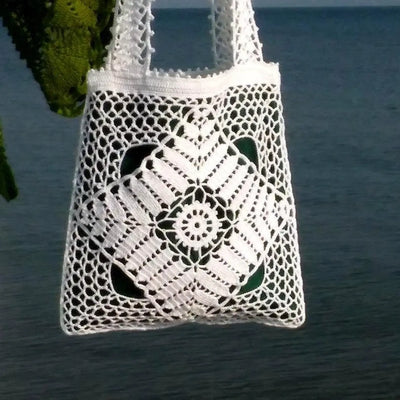 White crochet tote bag with beautiful openwork lace pattern and green linen lining, ideal for stylish and practical use.
