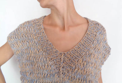 Close-up of a woman wearing a multicolor alpaca blend sweater vest with a V neck and short sleeves.