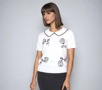 Donna Hayward inspired white blouse with Peter Pan collar and black rose embroidery, featuring short sleeves.