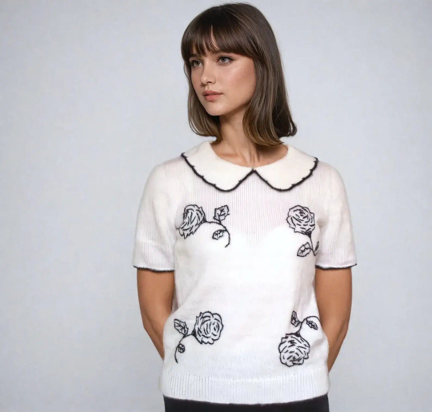 Donna Hayward-inspired white blouse featuring black rose embroidery and Peter Pan collar, perfect for vintage style lovers.