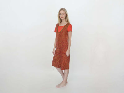 Short knitted jumpsuit for women in a vibrant red and orange gradient with pockets and a stylish V-neck design.