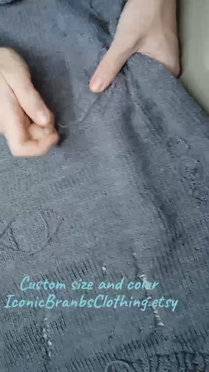 Close-up of a distressed gray cable knit sweater showing detailed texture and custom sizing options.