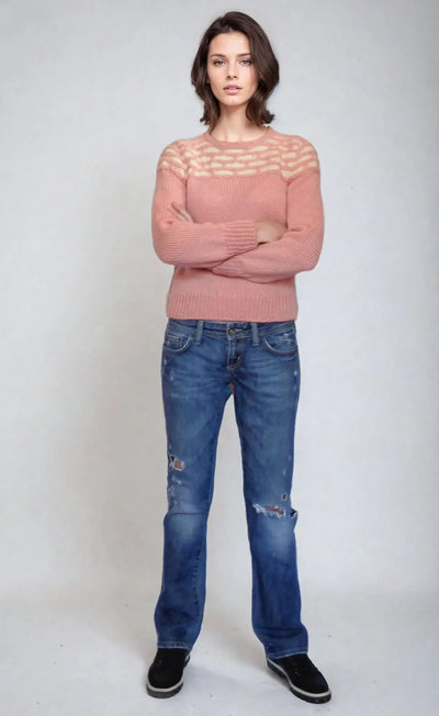 Model showcasing Honeycomb pink sweater from Promising Young Woman, styled with casual jeans for a chic look.